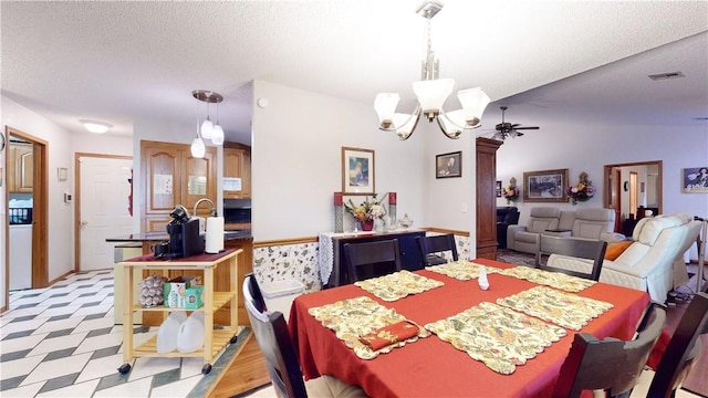 dining room featuring visible vents, light floors, a textured ceiling, and an inviting chandelier