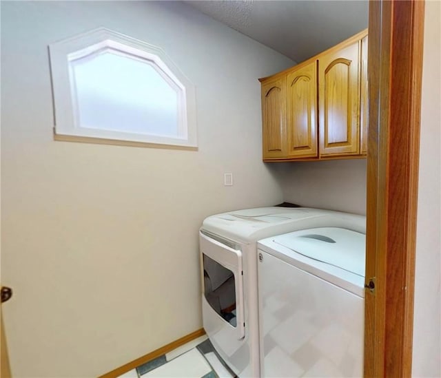 washroom with separate washer and dryer, cabinet space, and tile patterned floors