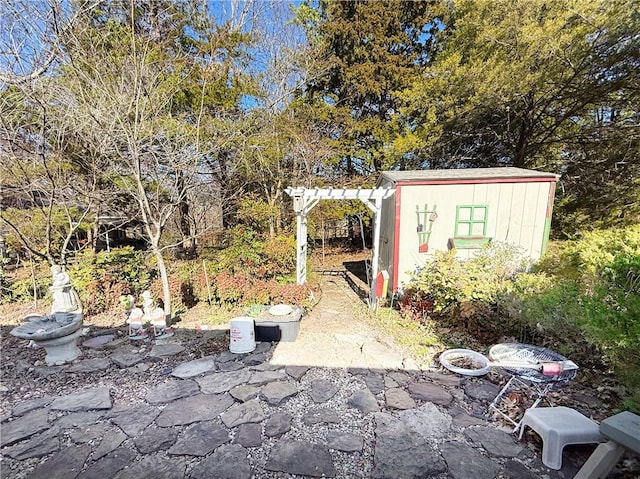 view of yard featuring a storage shed, a pergola, and an outdoor structure