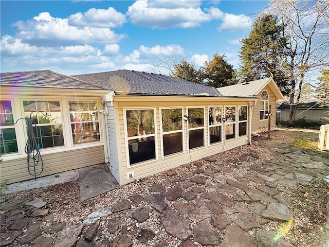 rear view of property featuring roof with shingles