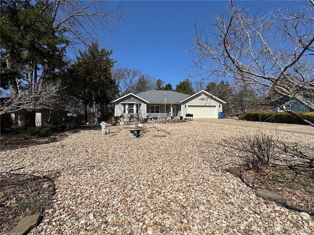 single story home featuring a garage, a porch, and driveway