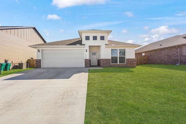 prairie-style home with a front yard, fence, an attached garage, concrete driveway, and brick siding