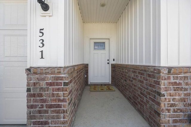 doorway to property featuring brick siding and a garage