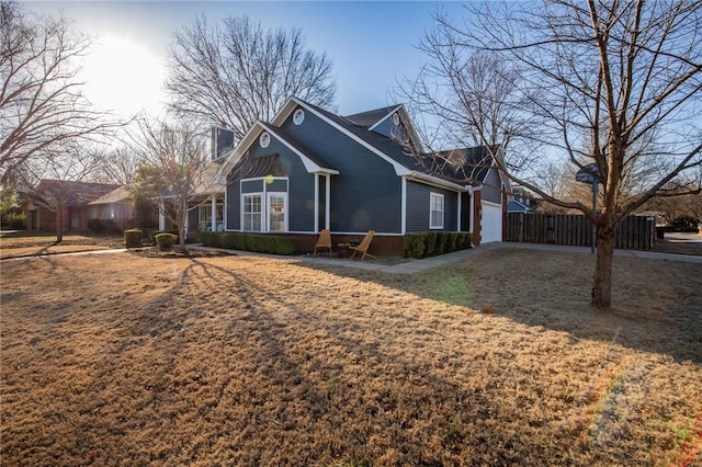 view of property exterior with a chimney, an attached garage, and fence