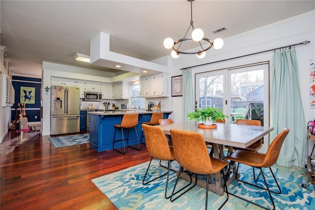 dining room featuring visible vents, dark wood-type flooring, and an inviting chandelier