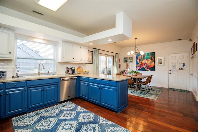 kitchen with blue cabinets, visible vents, a sink, stainless steel dishwasher, and a peninsula