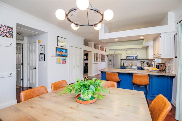 dining area featuring recessed lighting, baseboards, an inviting chandelier, and ornamental molding