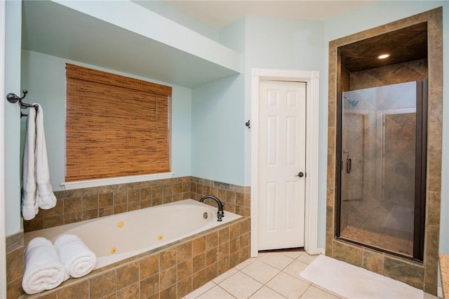 bathroom featuring a shower stall, a whirlpool tub, and tile patterned flooring