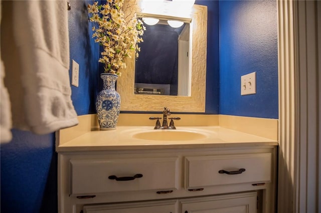 bathroom featuring vanity and a textured wall