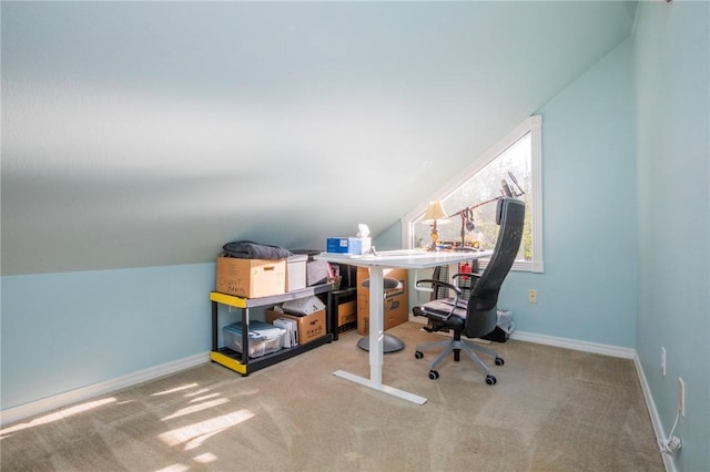 carpeted home office with lofted ceiling and baseboards