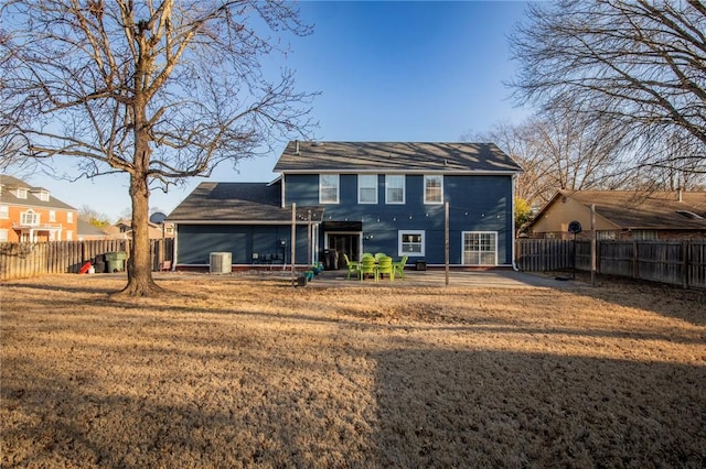 back of property featuring central air condition unit, a fenced backyard, and a lawn