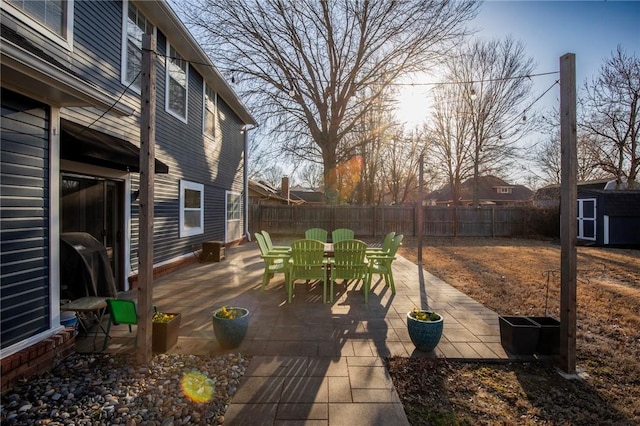 exterior space with a storage shed, an outbuilding, a fenced backyard, and a patio