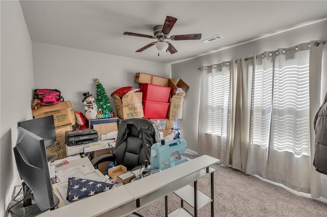 carpeted home office with visible vents and ceiling fan