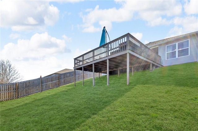 back of house featuring a lawn, a deck, and fence