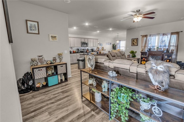 living area with recessed lighting, light wood-style floors, and ceiling fan