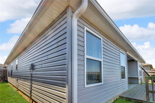 view of home's exterior featuring a wooden deck, a yard, and fence