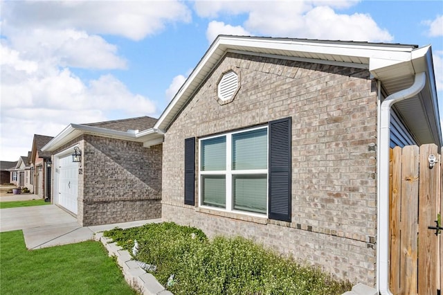 view of side of property featuring brick siding, concrete driveway, and a garage