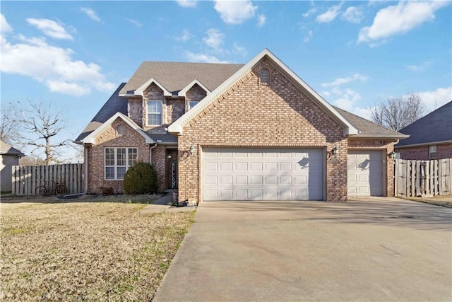 view of front of home with brick siding, an attached garage, concrete driveway, and fence