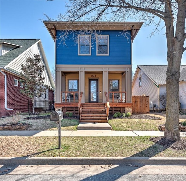 view of front of property with a porch and fence