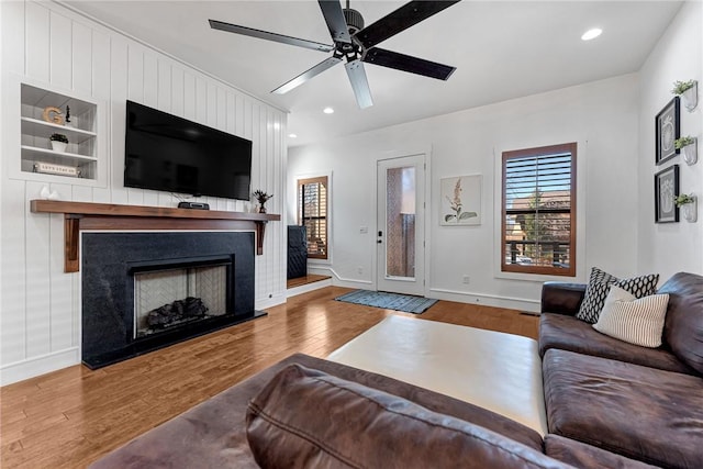 living area with baseboards, recessed lighting, a fireplace, wood finished floors, and a ceiling fan