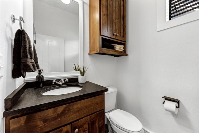 half bathroom with toilet and vanity