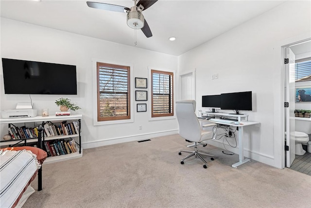 office space featuring carpet flooring, a ceiling fan, and baseboards