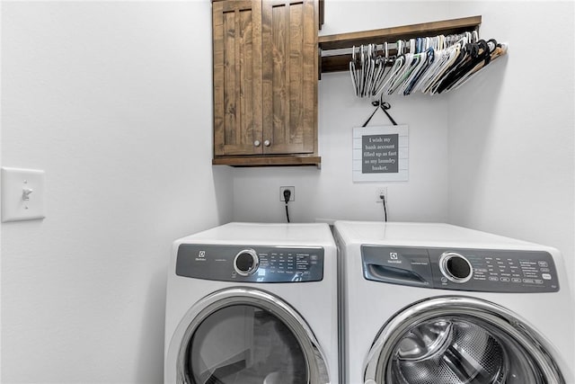 washroom with washing machine and clothes dryer and cabinet space