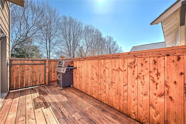 wooden deck with a grill and fence