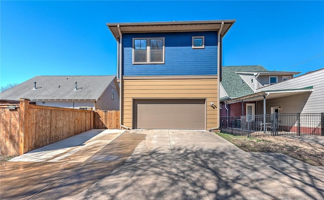 view of front of home featuring an attached garage, fence, and driveway