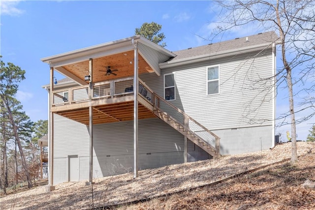 back of property with crawl space, a ceiling fan, and stairway