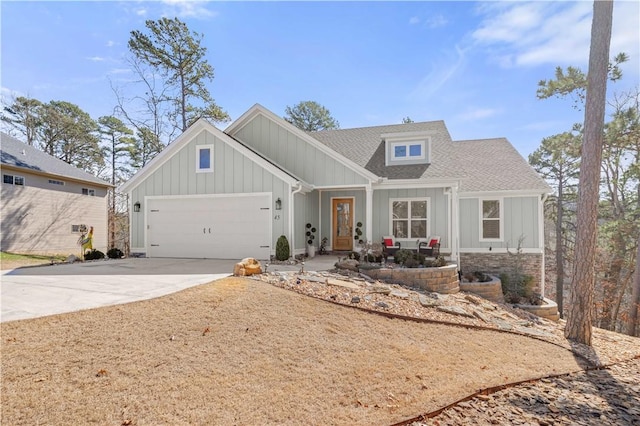 view of front of home featuring a garage, board and batten siding, driveway, and a shingled roof