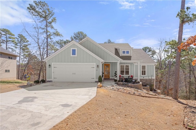 view of front of property with an attached garage, board and batten siding, driveway, and a shingled roof