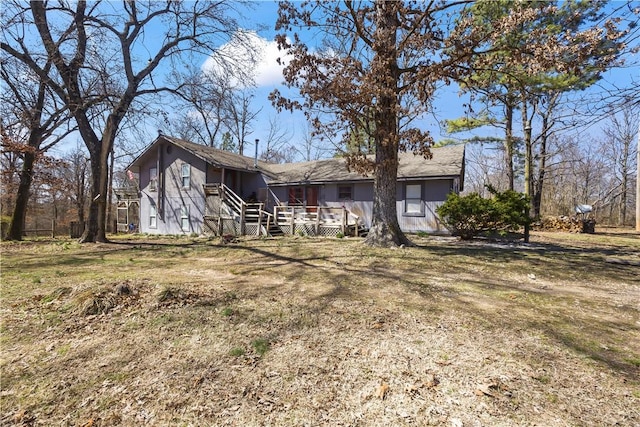 rear view of property featuring a wooden deck