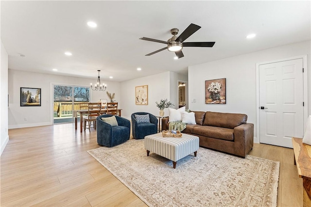 living room with recessed lighting, baseboards, light wood-style flooring, and ceiling fan with notable chandelier