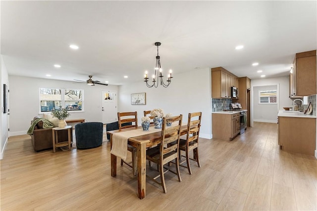 dining space featuring light wood-style flooring, recessed lighting, a healthy amount of sunlight, and baseboards