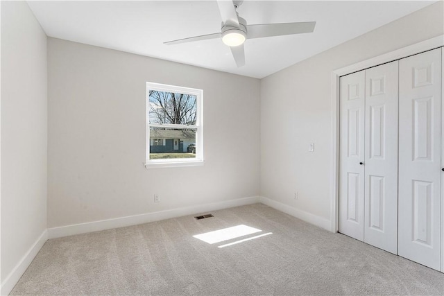 unfurnished bedroom with visible vents, a ceiling fan, a closet, carpet, and baseboards