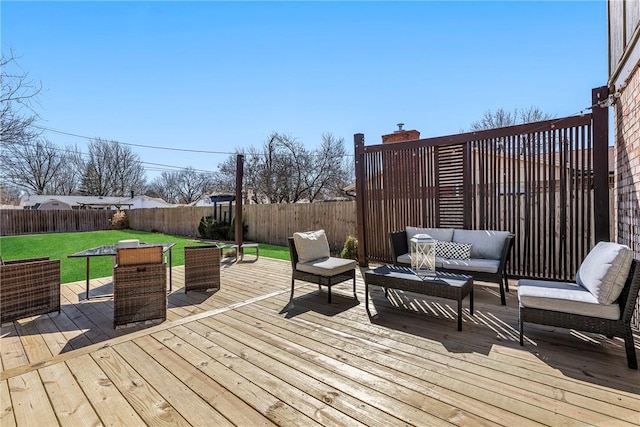 wooden deck featuring a yard, a fenced backyard, and outdoor lounge area