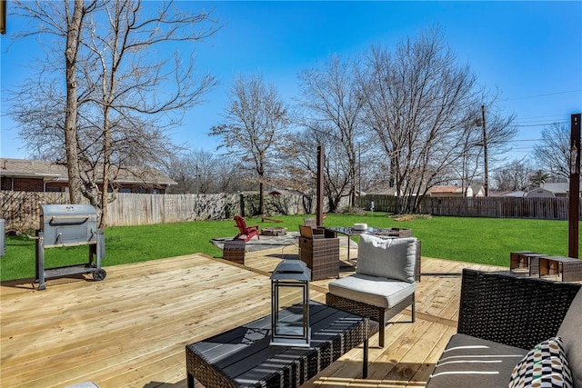 deck with area for grilling, a lawn, and a fenced backyard