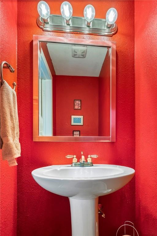 bathroom with a textured wall and a sink