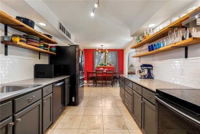 kitchen featuring stainless steel dishwasher, open shelves, and light tile patterned flooring