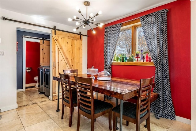 dining space with independent washer and dryer, a barn door, light tile patterned flooring, baseboards, and a chandelier