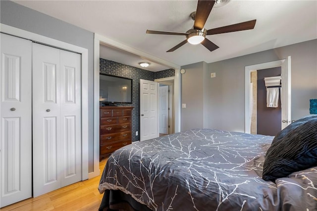 bedroom with a closet, a ceiling fan, and wood finished floors