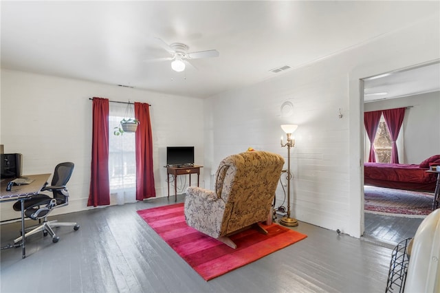 home office featuring hardwood / wood-style floors, a ceiling fan, and visible vents