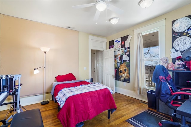 bedroom with visible vents, baseboards, and wood finished floors