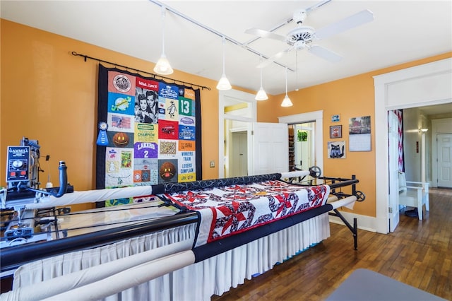 bedroom featuring track lighting, baseboards, and wood finished floors