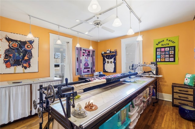 interior space with ceiling fan, hanging light fixtures, track lighting, baseboards, and wood-type flooring