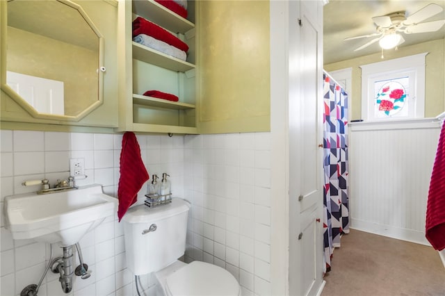 full bath featuring curtained shower, toilet, a ceiling fan, and a sink