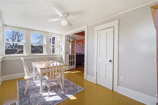 dining space with wood finished floors, baseboards, and ceiling fan