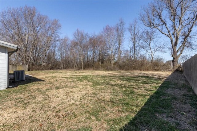 view of yard featuring central AC unit and fence