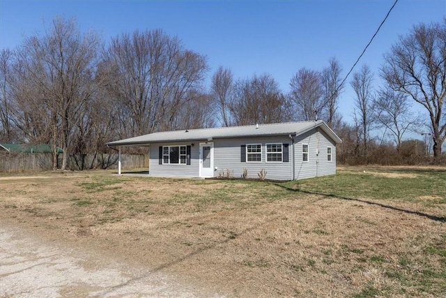 single story home featuring metal roof, a front lawn, and fence